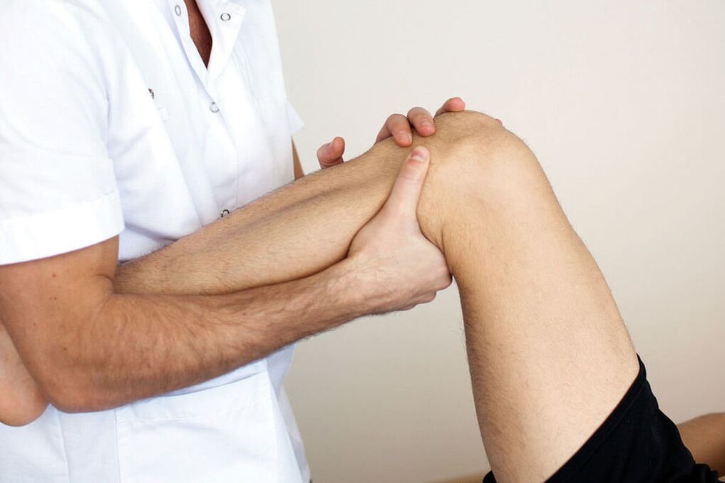Doctor examines a knee with osteoarthritis
